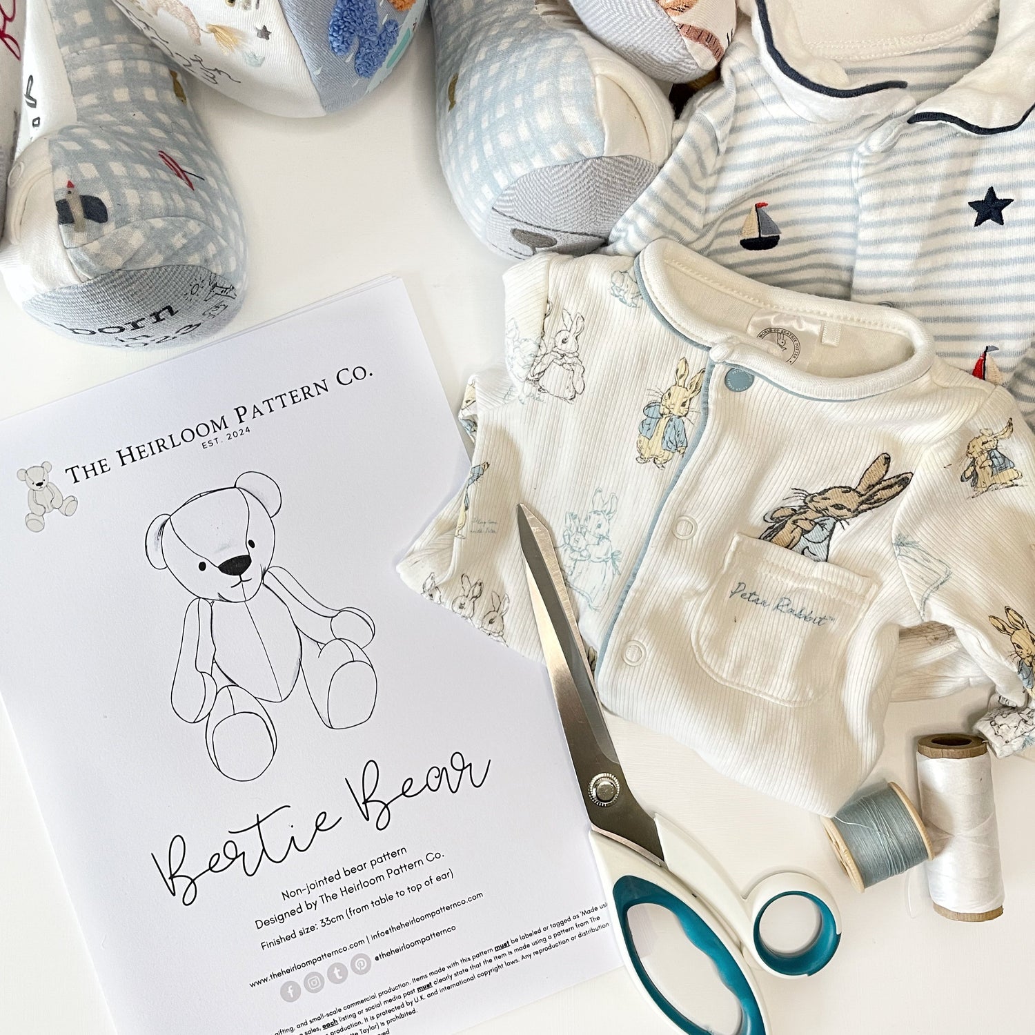 printed copy of bertie memory bear pattern with baby clothing and scissors